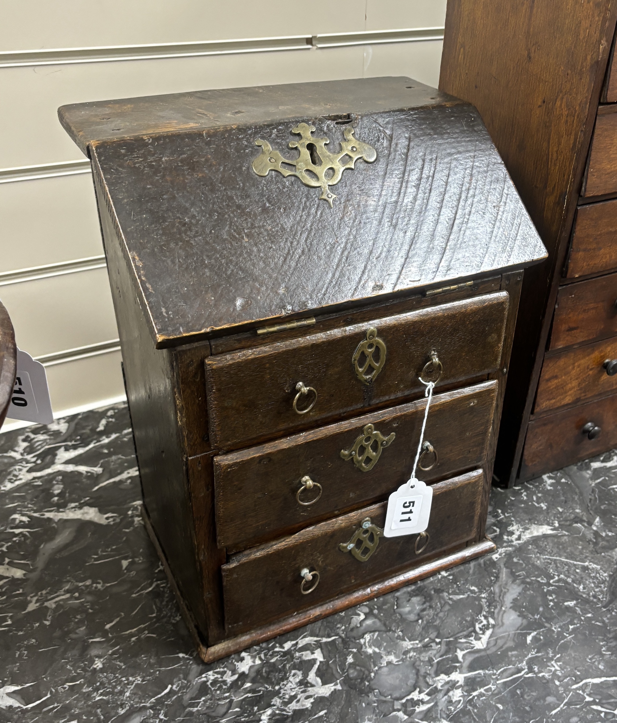 A miniature oak, brass mounted table top desk with three drawers, incorporating old timbers, 36cm high